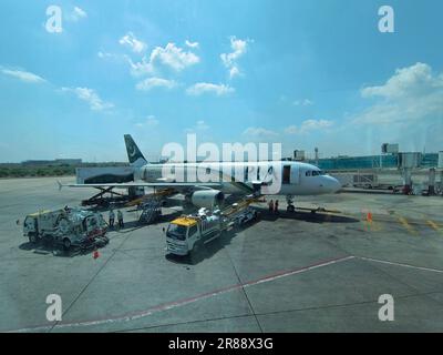 Pakistan International Airline à la porte du terminal de l'aéroport international de Karachi prêt pour le décollage Banque D'Images