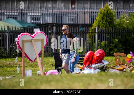 Les gens regardent les hommages floraux au parc du Roi George à Harryville, Ballymena, en souvenir de Chloe Mitchell. Ryan Johnston Gordon, 34 ans, de nursery Close, Ballymena, est apparu par liaison vidéo de la prison de Maghaberry, accusé d'avoir aidé un contrevenant à la suite du décès de Chloe, 21 ans, qui a été vu pour la dernière fois dans les premières heures de samedi 3 juin dans le centre-ville de Ballymena. Date de la photo: Mardi 20 juin 2023. Banque D'Images