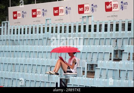 Berlin, Allemagne. 20th juin 2023. Tennis, WTA Tour Berlin, célibataires, femmes, 1st Round, Siegemund (Allemagne) - Blinkova (Fédération de Russie) : une femme fan de tennis est assise dans le court central avec un parapluie, lisant un livre pendant l'arrêt de jeu dû à l'apparition de la pluie. Credit: Wolfgang Kumm/dpa/Alay Live News Banque D'Images