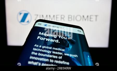 Téléphone mobile avec le site Web de la société américaine Zimmer Biomet Holdings Inc. À l'écran devant le logo d'entreprise. Faites la mise au point dans le coin supérieur gauche de l'écran du téléphone. Banque D'Images