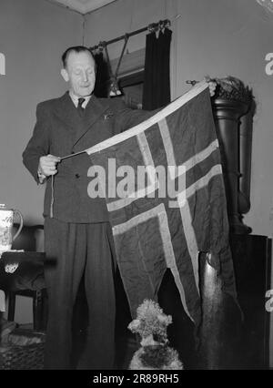 Réel 2-1947: Gulostende Johannes Andersen, mieux connu sous le nom de 'Gulosten', est l'un des plus célèbres cambrioleurs de Norvège. Au cours de la guerre, il a fait un excellent effort tant au pays qu'à l'étranger. Dans son livre 'VI kommer oss', Johannes Andersen donne un aperçu de sa vie colorée. Johs. Affiche fièrement le drapeau du fidèle MTB 715 qui a coulé à Fosnavåg le 19 mai 1945 après une explosion dans le moteur. Photo : Th. Skotaam / Aktuell / NTB ***PHOTO NON TRAITÉE*** Banque D'Images