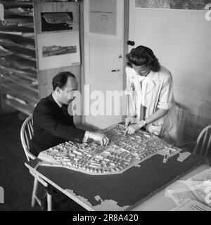 Réel 11-1-1947: Reconstruction à Kristiansund Kristiansund N. la ville construite sur des sébaste et des montagnes 803 maisons ont disparu dans un seul incendie énorme après le bombardement allemand en 1940. Les traces ont presque été effacées. Depuis 7 ans, ils ont vécu dans des casernes, aussi près que le hareng dans un baril. Tout le monde n'est pas encore revenu en ville. La ville est en train d'être reconstruite, mais cela prend du temps. L'architecte réglementaire Knut Cleve s'assure que les règlements sont respectés. Il « joue » avec ses blocs de construction sur le plan modèle, et beaucoup le remercieront certainement quand ils verront comment la ville devient belle. Banque D'Images