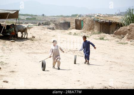 (230620) -- ISLAMABAD, 20 juin 2023 (Xinhua) -- des garçons jouent avec des pneus dans un camp de réfugiés lors de la Journée mondiale des réfugiés à Islamabad, au Pakistan, sur 20 juin 2023. Le Président pakistanais Arif Alvi a déclaré que son pays continue d'accueillir l'une des plus grandes populations de réfugiés au monde, montrant la détermination et l'engagement indéfectibles du Pakistan en faveur du bien-être et du rapatriement volontaire des réfugiés. Dans son message à l'occasion de la Journée mondiale des réfugiés observée mardi, Alvi a dit que «le jour, nous sommes rappelés à l'immense contribution du gouvernement et du peuple pakistanais en accueillant des millions de A. Banque D'Images
