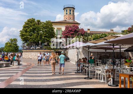 Touristes marchant le long de la promenade en bord de mer dans la ville pittoresque de Lazise, lac de Garde, Italie, Europe Banque D'Images