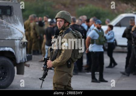 Eli, Israël. 20th juin 2023. Les officiers des forces de sécurité israéliennes se tiennent sur les lieux d'une fusillade dans la colonie d'Eli, entre Naplouse et Ramallah, en Cisjordanie. Selon l'armée israélienne, un attaquant palestinien présumé a ouvert le feu sur des civils près d'une station-service, a fait au moins quatre morts et quatre blessés. Crédit : Ilia Yefimovich/dpa/Alay Live News Banque D'Images