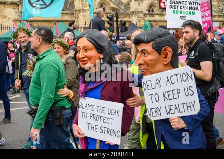 LONDRES - 22 avril 2023 : assistez à la représentation symbolique des manifestants du XR qui arborent des masques géants de Rishi Sunak et de sa femme, Akshata Murthy, à Extincti Banque D'Images