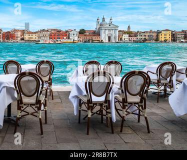 Tables et chaises en plein air un restaurant avec vue sur le canal à Venise, Italie. Banque D'Images