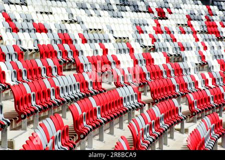 vue arrière en gros plan des sièges de stade en plastique. plancher sport en caoutchouc souple et pistes de course au-delà. concept d'athlétisme, de piste et de terrain et de compétition Banque D'Images