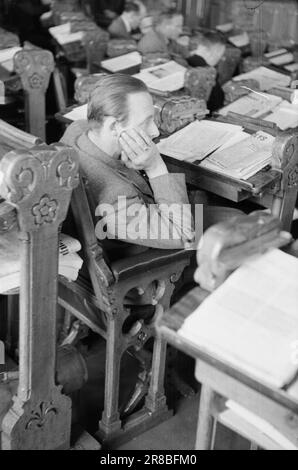 Réel 22-1946: Tout le pouvoir dans cette salle [photo 0063]la session d'automne du Storting en 1946 est l'une des plus importantes de notre histoire récente. Le débat financier a clairement montré que nous sommes au milieu d'un processus de transformation sociétale caractérisé par des interventions réglementaires dans le monde des affaires et par l'influence croissante des citoyens ordinaires sur la production et le chiffre d'affaires. Sur les 150 représentants du Storting, 112 sont nouveaux après la guerre. Nils Kristian Jacobsen de Skjervøy à Troms écoute avec intérêt. C'est un pêcheur et un petit agriculteur. Les Allemands ont brûlé son mil Banque D'Images