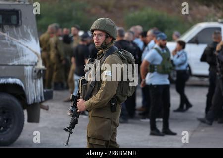 Eli. 20th juin 2023. Les officiers des forces de sécurité israéliennes se tiennent sur les lieux d'une fusillade dans la colonie d'Eli, entre Naplouse et Ramallah, en Cisjordanie. Selon l'armée israélienne, un attaquant palestinien présumé a ouvert le feu sur des civils près d'une station-service, a fait au moins quatre morts et quatre blessés. Crédit : Ilia Yefimovich/dpa/Alay Live News Banque D'Images