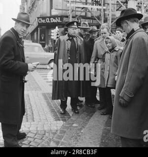 Actuel 13-7-1960: Qui a tourné? Un coup de feu a sorti de la chambre d'hôtel au cinquième étage d'une ferme en direction de la porte Karl Johans. Au même moment, un homme d'âge moyen s'est effondré dans un escalier en bas de la rue avec ses mains pressées à son estomac. Avant son départ, le contremaître de la station, Nils Mathiesen, âgé de 56 ans, s'est penché sur les gens qui l'entouraient : qui m'a tiré dessus ? Alors que les médecins se battaient pour la vie de Mathiesen et que les gens se précipitaient, les enquêteurs ont commencé leur travail approfondi. Après six heures de travail, ils ont pu répondre à la question. Photo: Ivar Aaserud / Aktuell / NTB ***PHOTO PAS D'IMAGE Banque D'Images