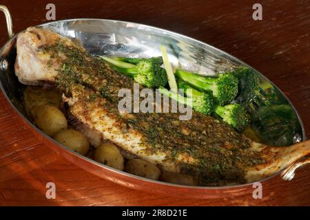 la sole traditionnelle française de délicatesse meunière avec légumes verts, pommes de terre et citrons câpres beurre dans une casserole de cuivre avec fond noir, semblable à colombe Banque D'Images