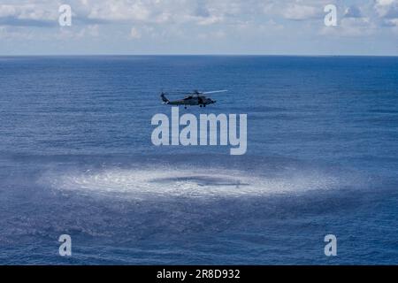 230618-N-KU796-1147 OCÉAN PACIFIQUE (18 juin 2023) un hélicoptère MH-60R Sea Hawk provenant des « Battlecats » de l'Escadron d'impact maritime (USM) 73 se prépare à abaisser un sonar aéroporté à basse fréquence (ALFS) dans l'eau près du porte-avions Nimitz (CVN 68). Nimitz mène actuellement des opérations de routine. (É.-U. Navy photo par Mass communication Specialist 2nd Class Samuel Osborn) Banque D'Images