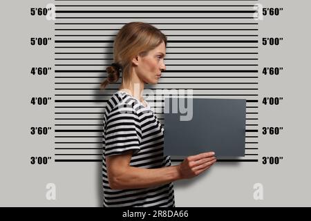 Coup de feu criminel. Femme arrêtée avec une carte vierge contre le tableau de hauteur Banque D'Images