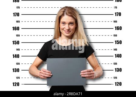 Coup de feu criminel. Femme arrêtée avec une carte vierge contre le tableau de hauteur Banque D'Images