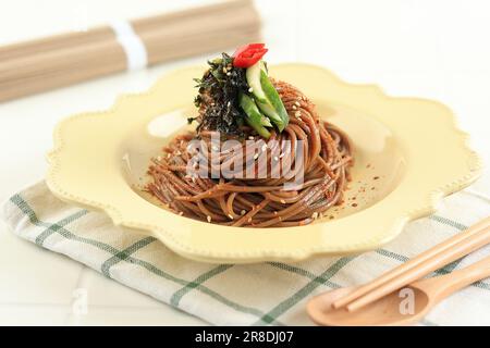 Nouilles de sarrasin coréennes Memil Makguksu sur plaque céramique crème. Chien épicé Noodle pour Bibim Guksu. Banque D'Images