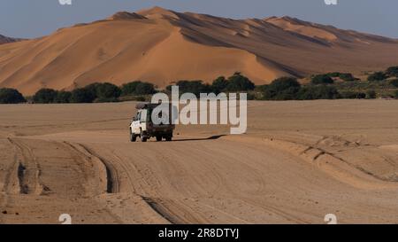 4x4 chevauchant à travers les dunes de sable dans le désert du Namib, Namibie Banque D'Images