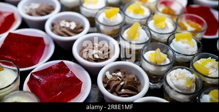 Concept de buffet de desserts. Dessert sélectif sur le comptoir du buffet. Dessert dans une assiette, une tasse et un verre à table au restaurant pour le déjeuner-buffet. Banque D'Images