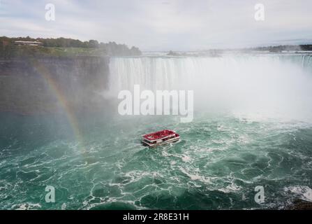 Rainbows et bateau de croisière aux chutes du Niagara. Touristes portant des imperméables roses sur le bateau. Canada. Banque D'Images