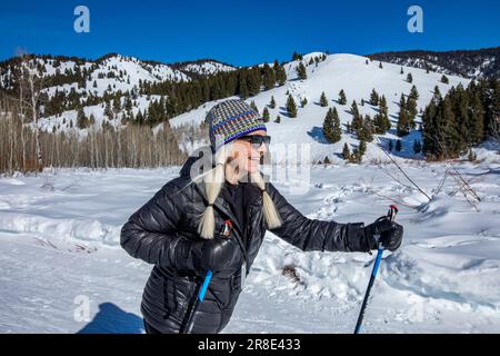États-Unis, Idaho, Ketchum, randonneur féminin senior randonnée dans les montagnes en hiver Banque D'Images