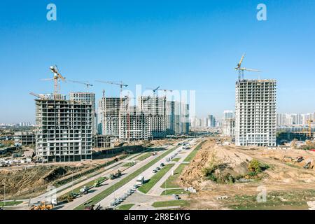 développement d'une nouvelle zone résidentielle. immeubles d'appartements en hauteur en construction avec grues sur fond bleu ciel. photo aérienne. Banque D'Images
