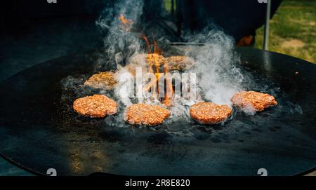 Préparation de viandes haburger de bœuf juteuses . La viande grillée au barbecue au-dessus de flammes chaudes. Banque D'Images