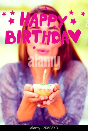 Composite de texte de joyeux anniversaire avec des étoiles sur jeune femme caucasienne tenant cupcake avec bougie Banque D'Images