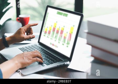 Une jeune femme de garde bancaire utilisant une calculatrice, un ordinateur portable, une feuille de travail papier pour analyser les informations de données. Elle est une financière professionnelle de ba Banque D'Images