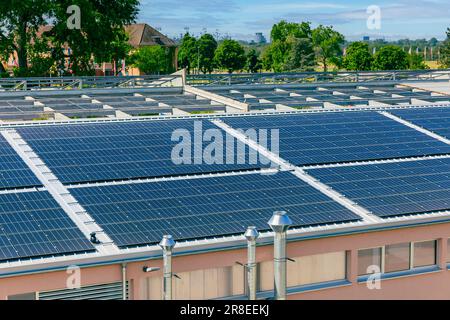 Panneaux solaires installés sur le toit d'un grand bâtiment industriel ou d'un entrepôt. Banque D'Images