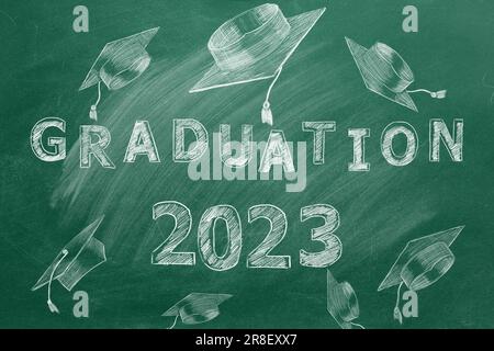 Texte dessiné à la main, GRADUATION 2023 et capuchons de graduation sur tableau noir vert. Banque D'Images