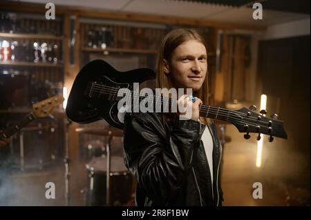 Portrait d'un guitariste de rock souriant portant un instrument de musique sur l'épaule Banque D'Images