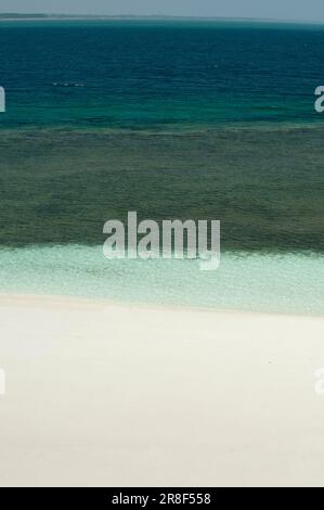 Les vagues de l'océan Cristal se brisent sur une plage de sable blanc avec de l'eau turquoise émeraude - photo de stock Banque D'Images