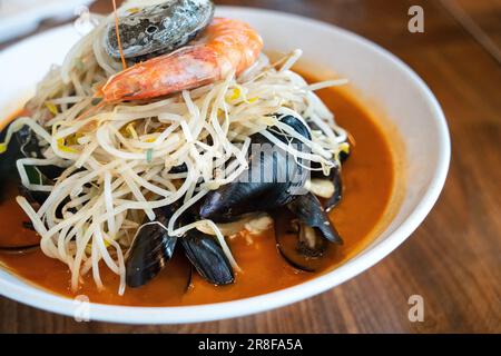 Délicieux jjamppong, jjambbong, soupe de nouilles coréennes de style chinois avec fruits de mer rouges épicés et bouillon de kimchi en Corée du Sud. Banque D'Images