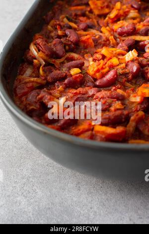 Petits déjeuners et déjeuners sains, haricots rouges avec carottes, oignons et tomates, vue de dessus d'un plat à rôtir ovale en céramique avec légumes secs Banque D'Images