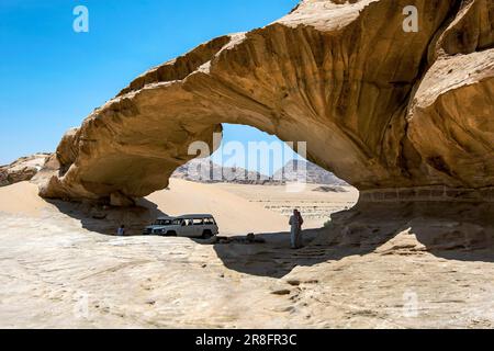 Véhicules garés sous l'ombre du pont à Wadi Rum en Jordanie. Wadi Rum est également connu comme la Vallée de la Lune. Banque D'Images