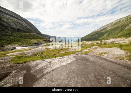 Randonnée à Husedalen, Norvège, par une journée d'été partiellement ensoleillée. Le temps est bon et il y a de bonnes vues sur le sentier. Hardangerfjord visible à distance. Banque D'Images