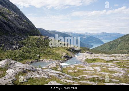 Randonnée à Husedalen, Norvège, par une journée d'été partiellement ensoleillée. Le temps est bon et il y a de bonnes vues sur le sentier. Hardangerfjord visible à distance. Banque D'Images