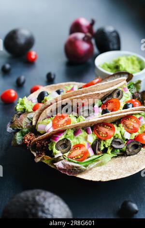 Un déjeuner ou un dîner sain d'un enveloppement de Taco végétalien / végétarien à coque molle fait de quinoa rouge avec saison de Taco, laitue romaine, tomates, guacamole. Banque D'Images