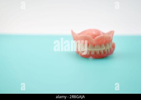 Dentiers sur une table de travail verte dans une clinique de dentiers. Banque D'Images