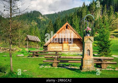 Paysage rural de printemps dans les montagnes. Cabane en bois et sanctuaire dans la belle vallée de montagne à l'ouest de Tatra, Pologne. Banque D'Images