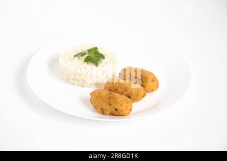 Boulettes de morue, ou « bolinhos de bacallahau », très célèbre dans la gastronomie portugaise. Assiette de pâtisseries à la morue servies avec du riz blanc. Banque D'Images