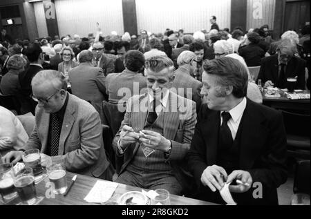 Hommes jouant à Bingo UK 1980s. Coventry Working Mens Club, soirée de bingo le samedi soir. Tous habillés et élégants, deux amis hommes bavardent et fument. Coventry, Angleterre vers 1981. Banque D'Images