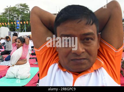 Mumbai, Inde. 21st juin 2023. Une femme (en arrière-plan) portant une saree effectue un exercice de yoga tout en étant assise sur un tapis à la porte de l'Inde à l'occasion de la Journée internationale du yoga à Mumbai. 9th la Journée internationale du yoga a été célébrée le 21st juin 2023 dans le monde entier. Le thème de la journée de yoga était 'Vasidhaiva Kutumbakam' une phrase sanskrit signifiant 'le monde entier est une famille' Credit: SOPA Images Limited/Alay Live News Banque D'Images