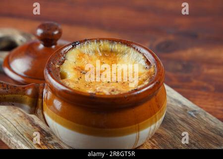 Bœuf braisé avec pommes de terre cuites au four sous la croûte de fromage dans un bol en argile. Style rustique Banque D'Images