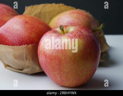 Un gros plan de pommes rouges savoureuses sur une table blanche Banque D'Images