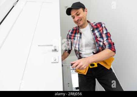 Réparation du bouton de porte sur la porte intérieure par un réparateur Banque D'Images