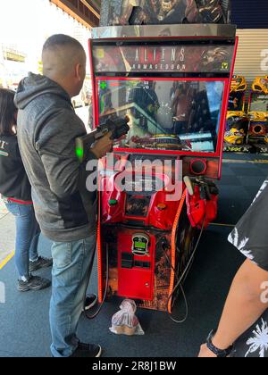 Man joue à un jeu vidéo violent dans une salle d'arcade à Coney Island, sur la plage de Brooklyn, New York. Banque D'Images