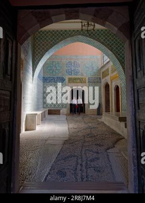 Les fonctionnaires marchent dans une salle magnifiquement élégante avec des carreaux bleus et des bancs en pierre et le sol dans le palais de Topkapi, quartier de Fatih, Istanbul, Turquie Banque D'Images