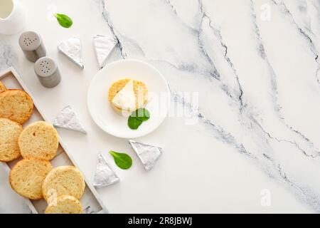 Assiettes avec des croûtons et des triangles de savoureux fromage fondu sur fond de marbre blanc Banque D'Images