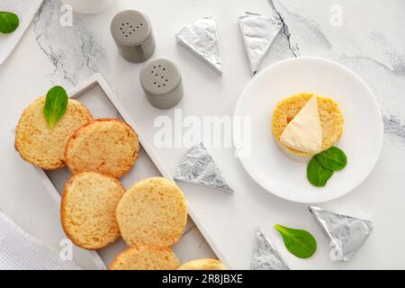 Assiettes avec des croûtons et des triangles de savoureux fromage fondu sur fond de marbre blanc Banque D'Images